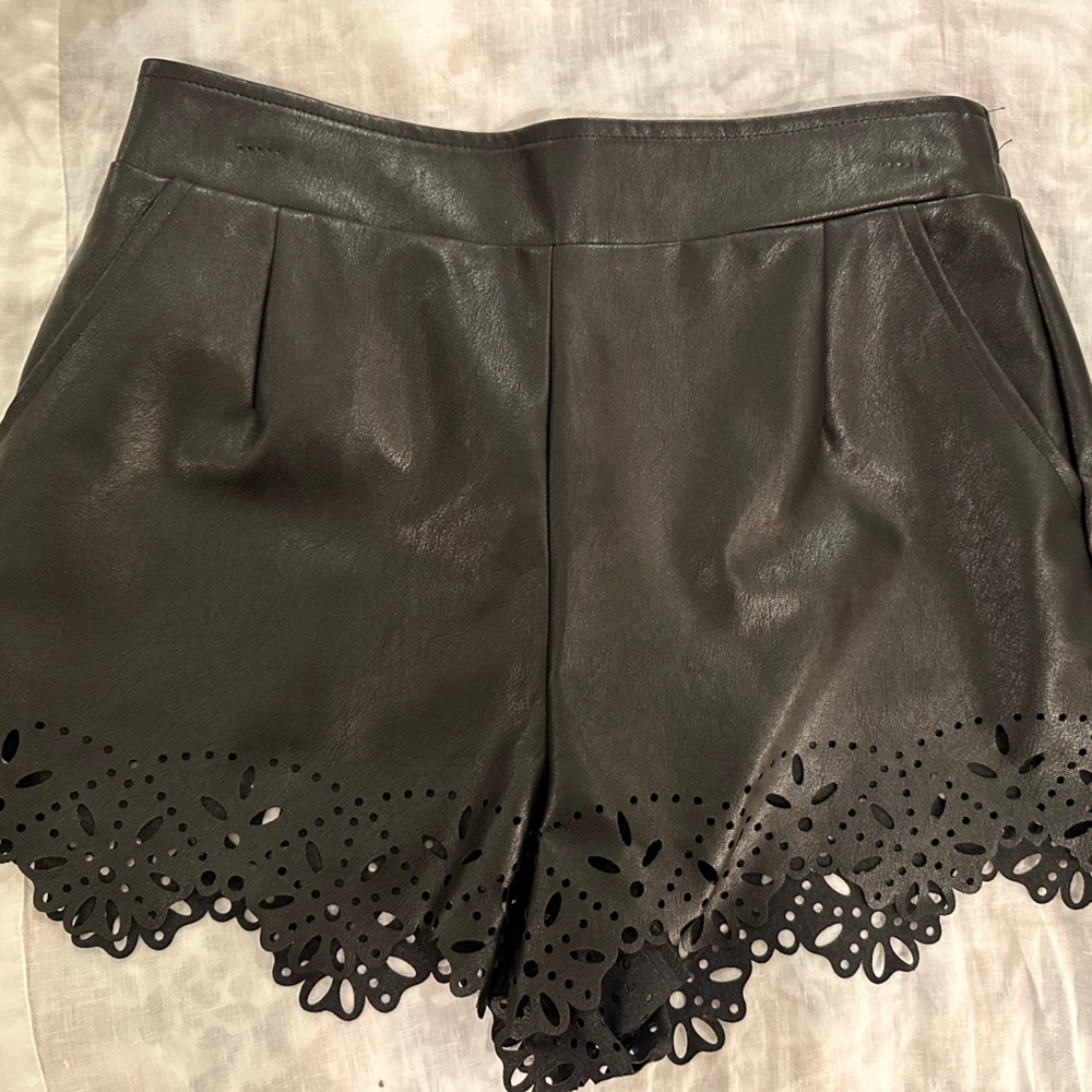 Black faux leather scalloped shorts.